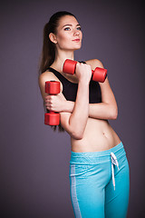 Image showing Portrait of young woman with dumbbells