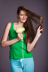 Image showing Woman with hair dryer