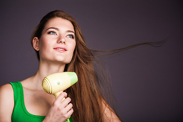 Image showing Woman with hair dryer