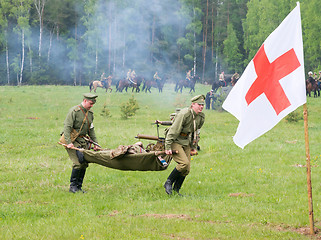 Image showing men of medical squad move a wounded soldier