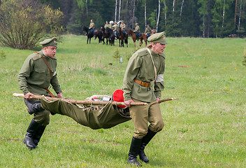 Image showing men of medical squad move a wounded soldier