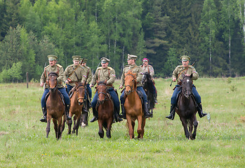 Image showing Cavalry soldiers ride on horses across the field