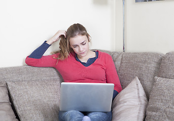 Image showing Young woman with laptop on sofa