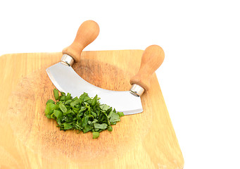 Image showing Chopped fresh basil leaves with a rocking knife