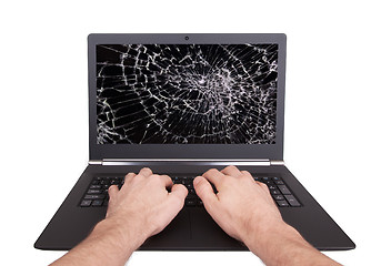 Image showing Man working on a laptop with a broken screen