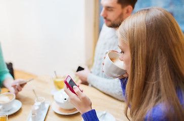 Image showing couple with smartphones drinking tea