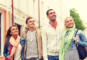 Image showing group of smiling friends walking in the city