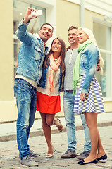 Image showing group of smiling friends making selfie outdoors