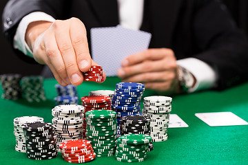 Image showing poker player with cards and chips at casino