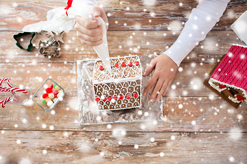 Image showing close up of woman making gingerbread houses