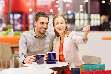 Image showing happy couple with shopping bags drinking coffee