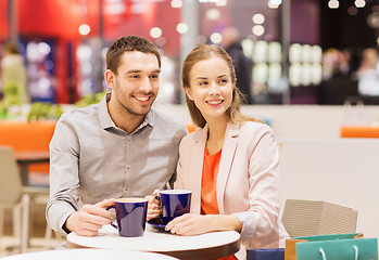 Image showing happy couple with shopping bags drinking coffee