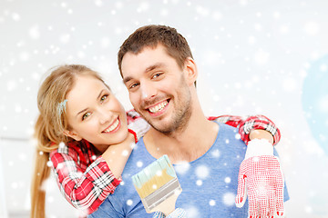 Image showing smiling couple with paintbrush at home