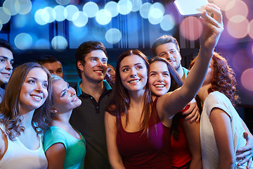 Image showing friends with smartphone taking selfie in club