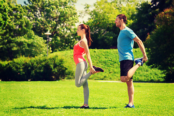 Image showing smiling couple stretching outdoors