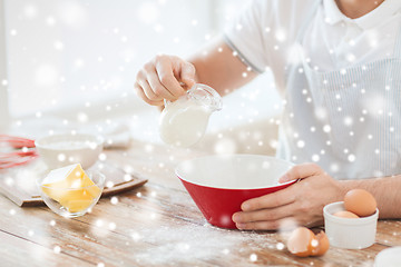 Image showing close up of man pouring milk to bowl