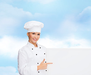 Image showing smiling female chef with white blank board