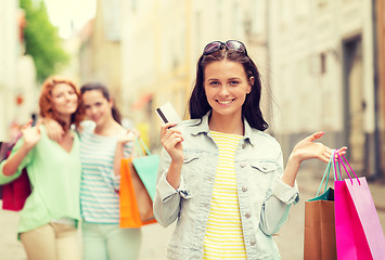 Image showing smiling teenage girls with shopping bags on street