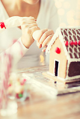 Image showing close up of woman making gingerbread house at home