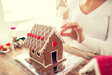 Image showing close up of woman making gingerbread houses