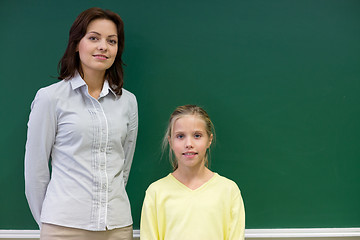 Image showing little school girl with teacher at blackboard