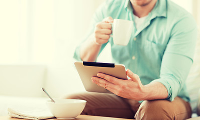 Image showing close up of man with tablet pc having breakfast