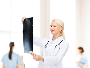 Image showing smiling female doctor looking at x-ray image