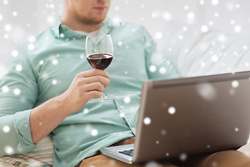 Image showing close up of man with laptop and wine glass