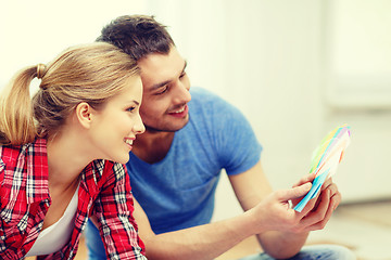 Image showing smiling couple looking at color samples at home