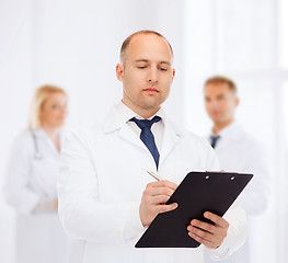 Image showing serious male doctor with clipboard