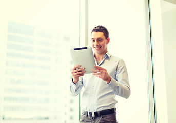 Image showing smiling businessman with tablet pc in office