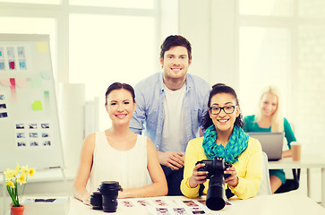 Image showing smiling team with photocamera working in office