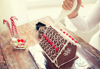 Image showing close up of woman making gingerbread houses