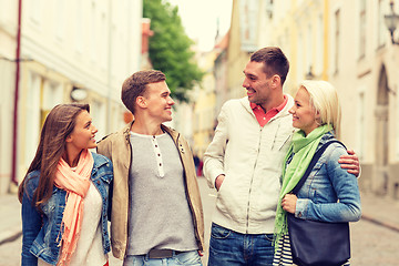 Image showing group of smiling friends walking in the city