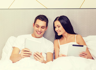 Image showing smiling couple in bed with tablet pc computers