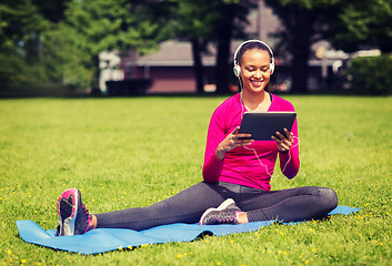 Image showing smiling woman with tablet pc outdoors