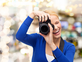 Image showing smiling woman taking picture with digital camera