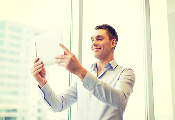 Image showing smiling businessman with tablet pc in office