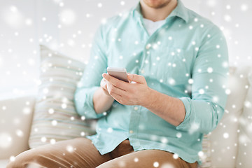 Image showing close up of man sitting with smartphone at home