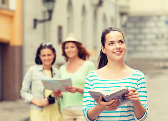 Image showing smiling teenage girls with city guides and camera