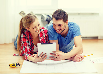 Image showing smiling couple looking at tablet pc at home