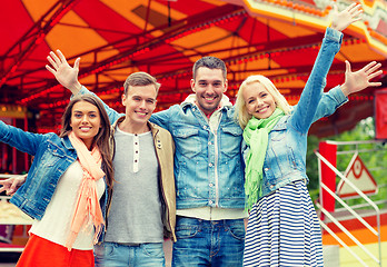 Image showing group of smiling friends waving hands