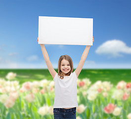 Image showing smiling little girl holding blank white board