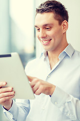 Image showing smiling businessman with tablet pc in office