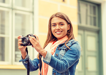 Image showing smiling girl with digiral photocamera in the city