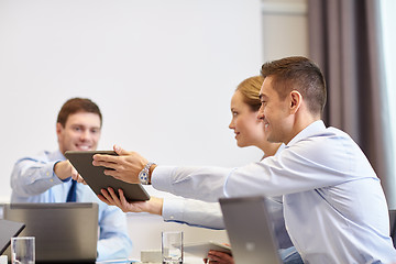 Image showing smiling business people with tablet pc in office