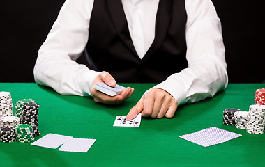 Image showing holdem dealer with playing cards and casino chips