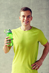 Image showing smiling man with bottle of water in gym