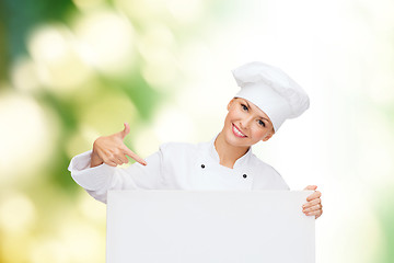 Image showing smiling female chef with white blank board