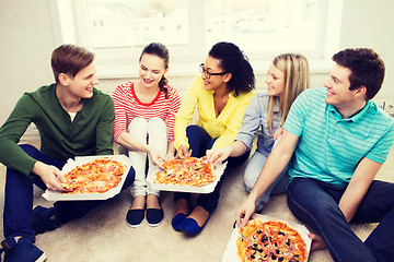 Image showing five smiling teenagers eating pizza at home